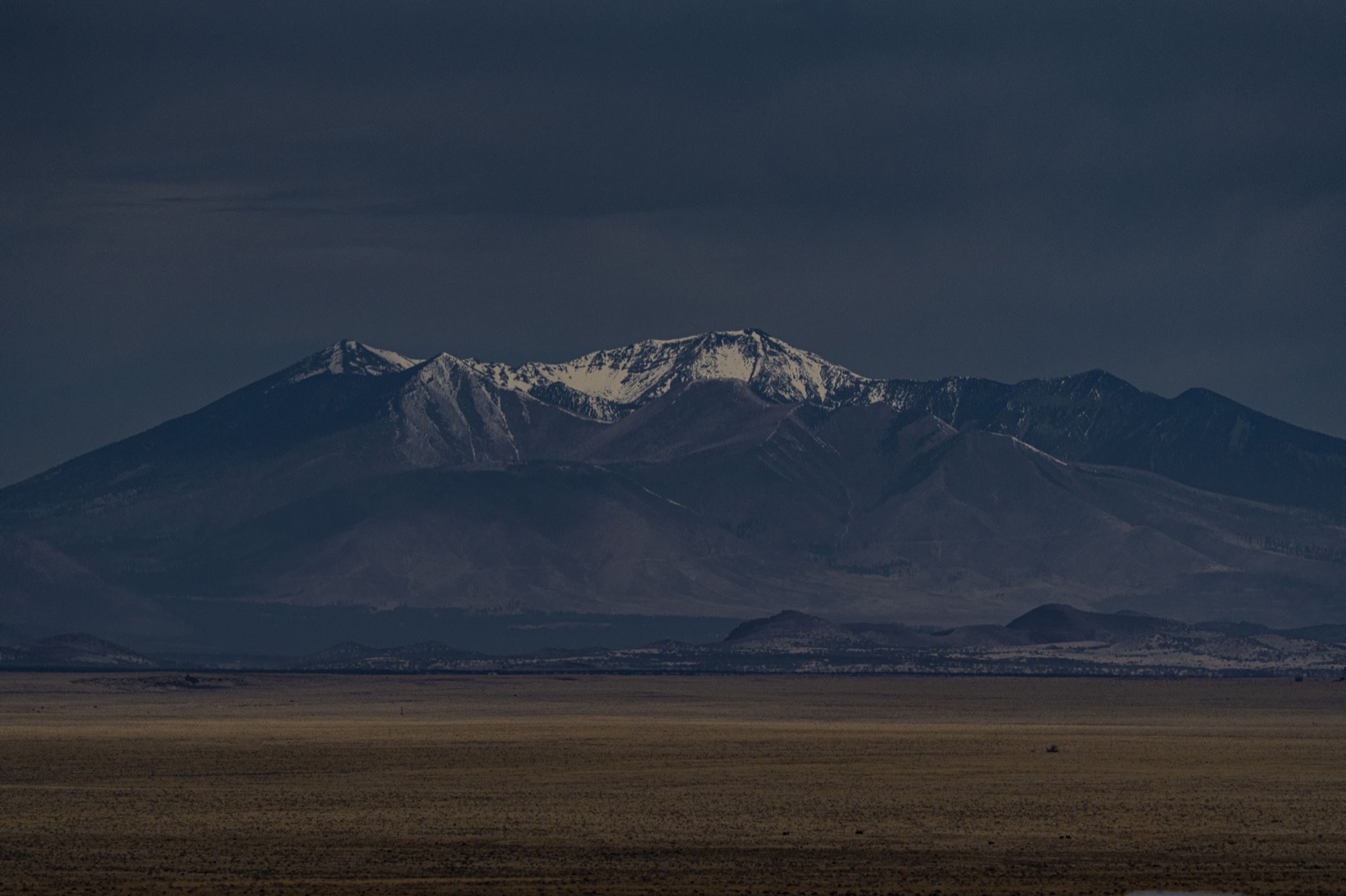 Snow peaks under a storm sky